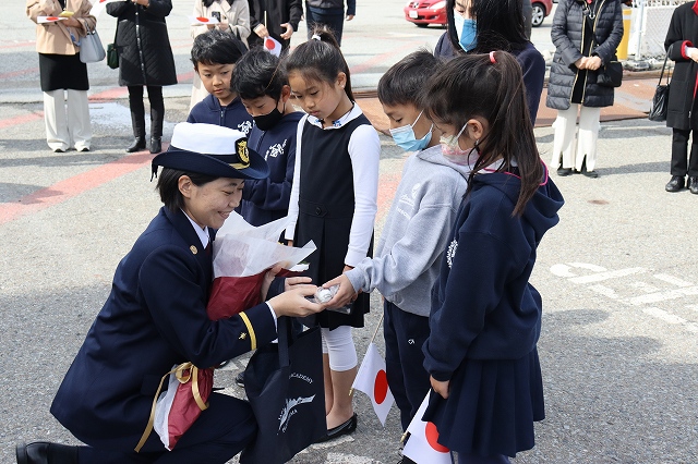入港歓迎式で子供たちから花束を受け取る実習生